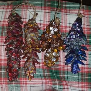 A Set Of Four Decorated Pine Cones..